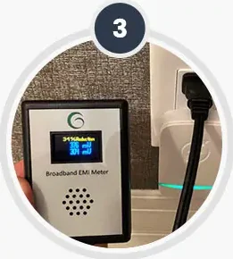 A small meter held beside the unit to confirm it is working